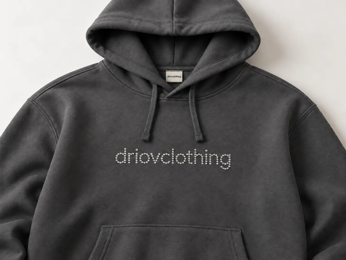 Rhinestone lettering detail against charcoal hoodie fabric.