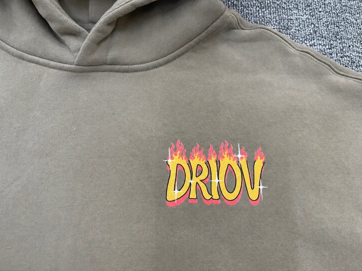 Yellow DRIOV lettering with a red flame graphic on a grey hoodie.