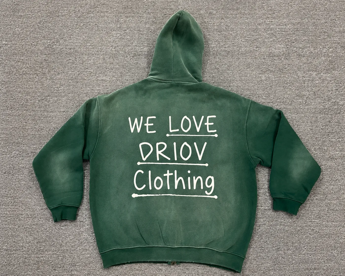 Light stacked lettering on the back of a green hoodie.