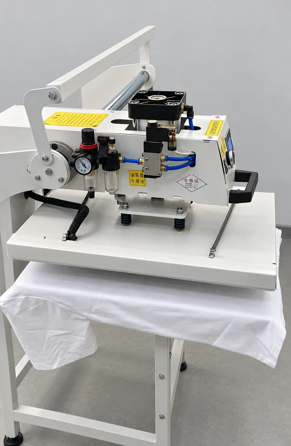 A heat-transfer press with white garment fabric beneath the pressing plate.