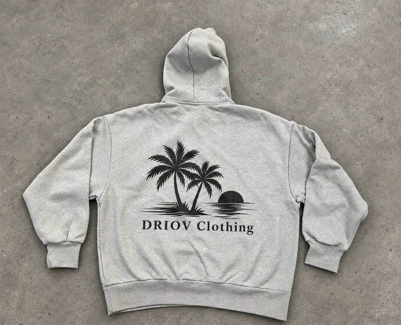 Grey hoodie with a black palm-tree graphic on the back.