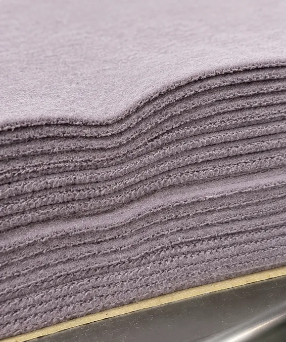 Close view of the aligned edges of stacked purple fabric panels.
