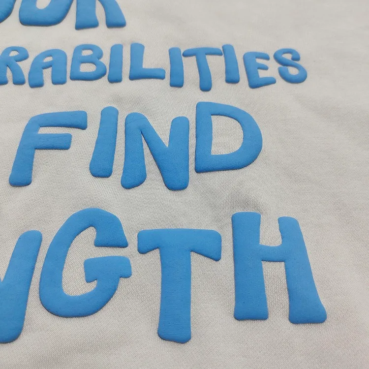 Raised blue block lettering on light fabric.