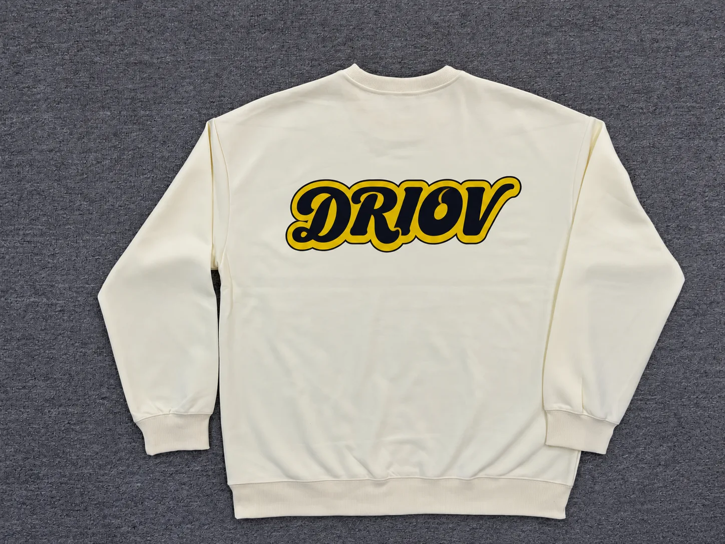 Cream crewneck sweatshirt with a yellow and black DRIOV chest graphic.