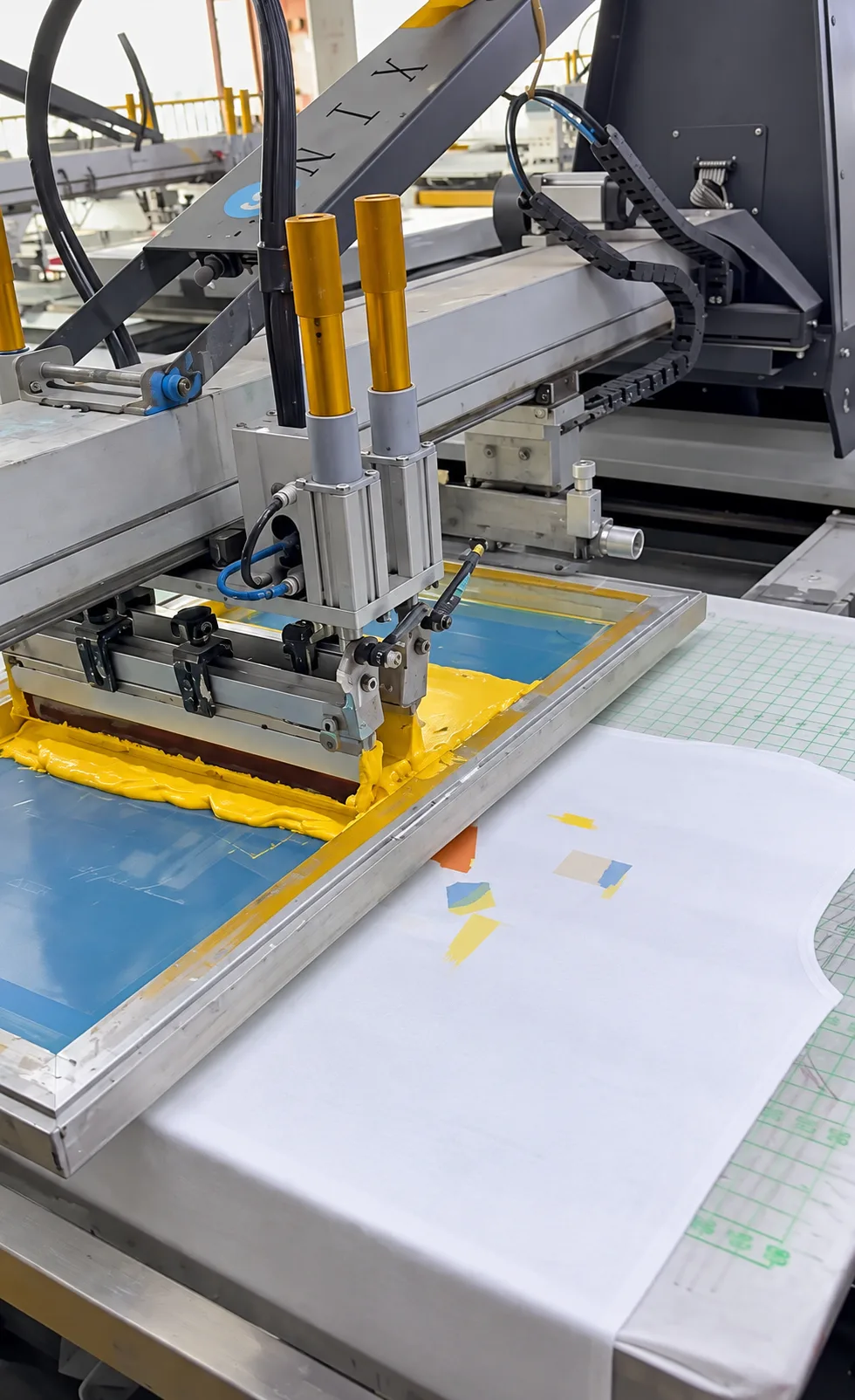 Yellow ink on a screen above a printed garment panel.