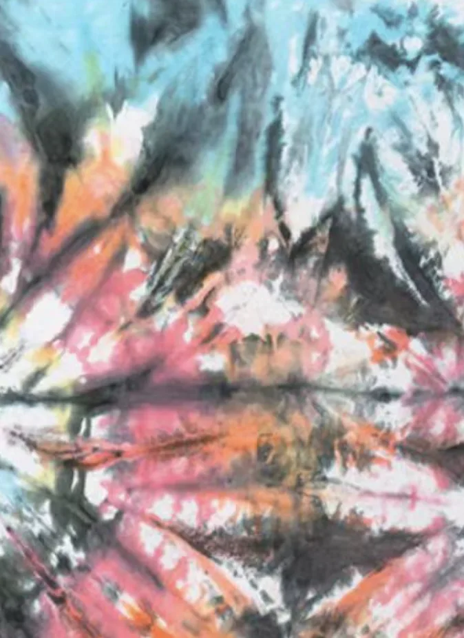Close view of an irregular tie-dye pattern in blue, pink, orange and dark tones.
